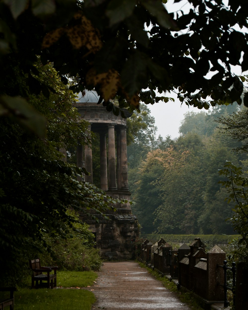 a stone monument in a park with trees in the background