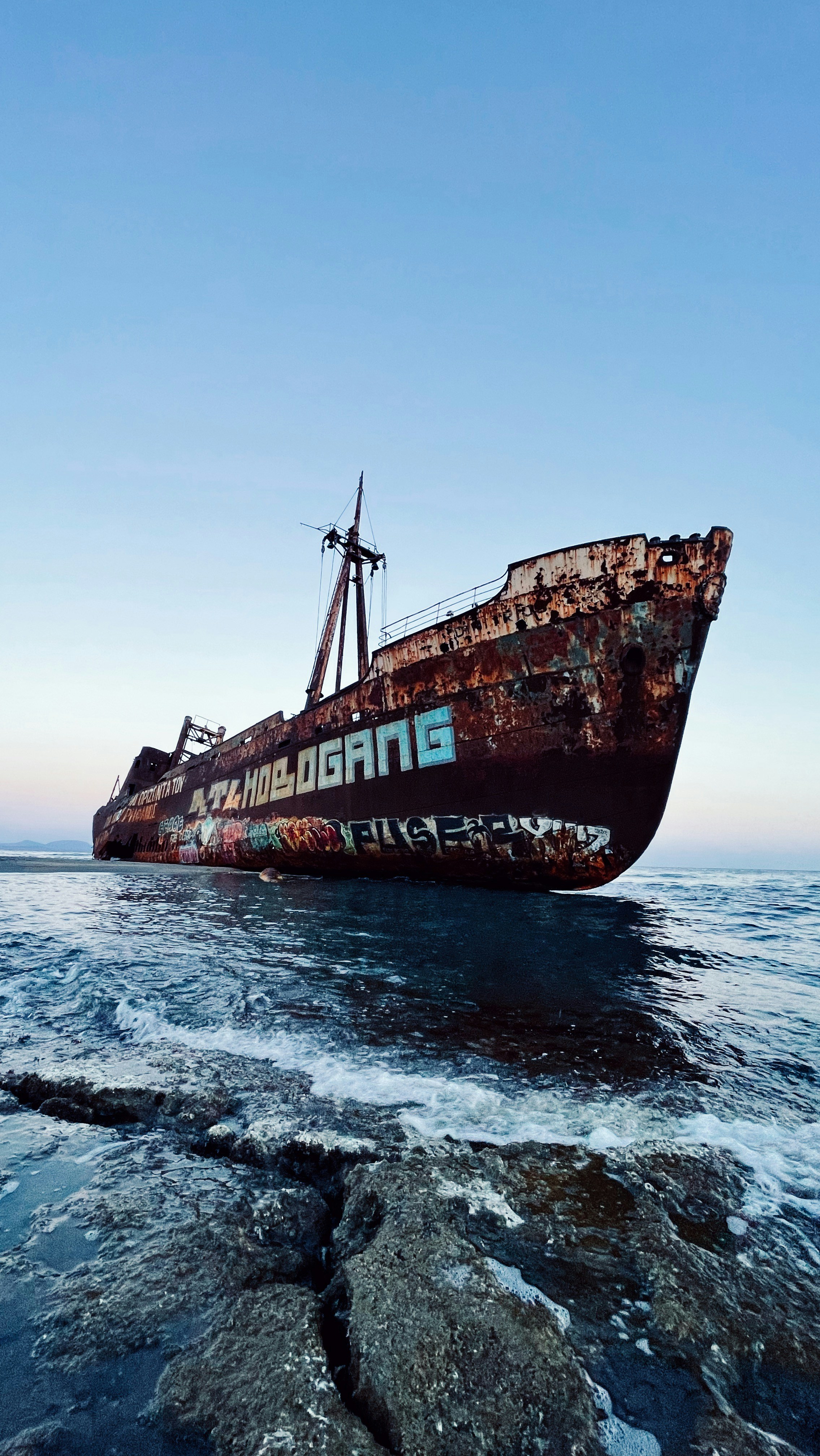 an old rusted ship in the middle of the ocean
