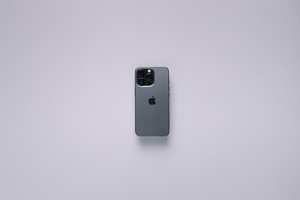 the back of an apple phone on a white surface
