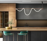 a modern kitchen with a bar and stools