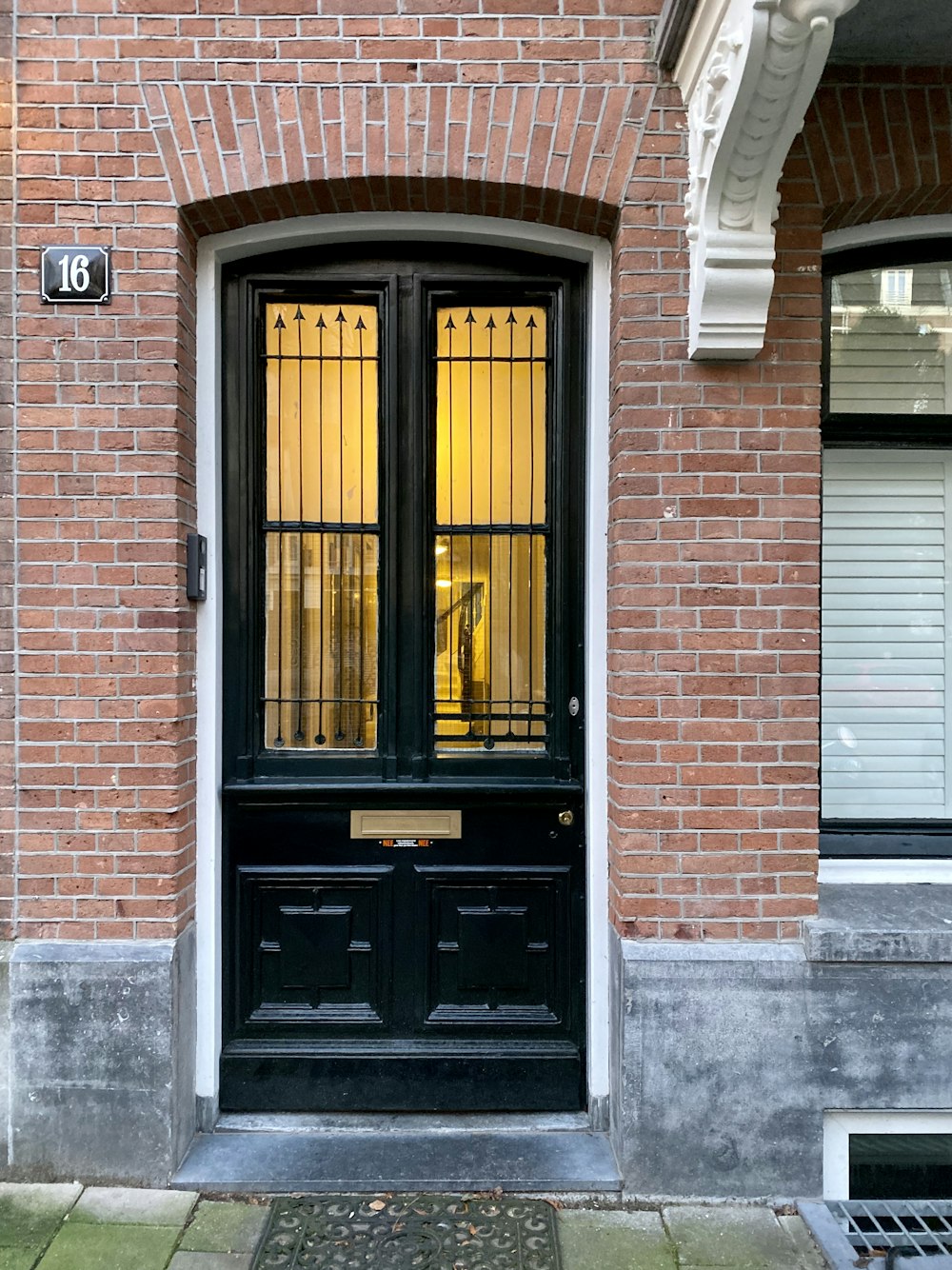a brick building with a black door and window
