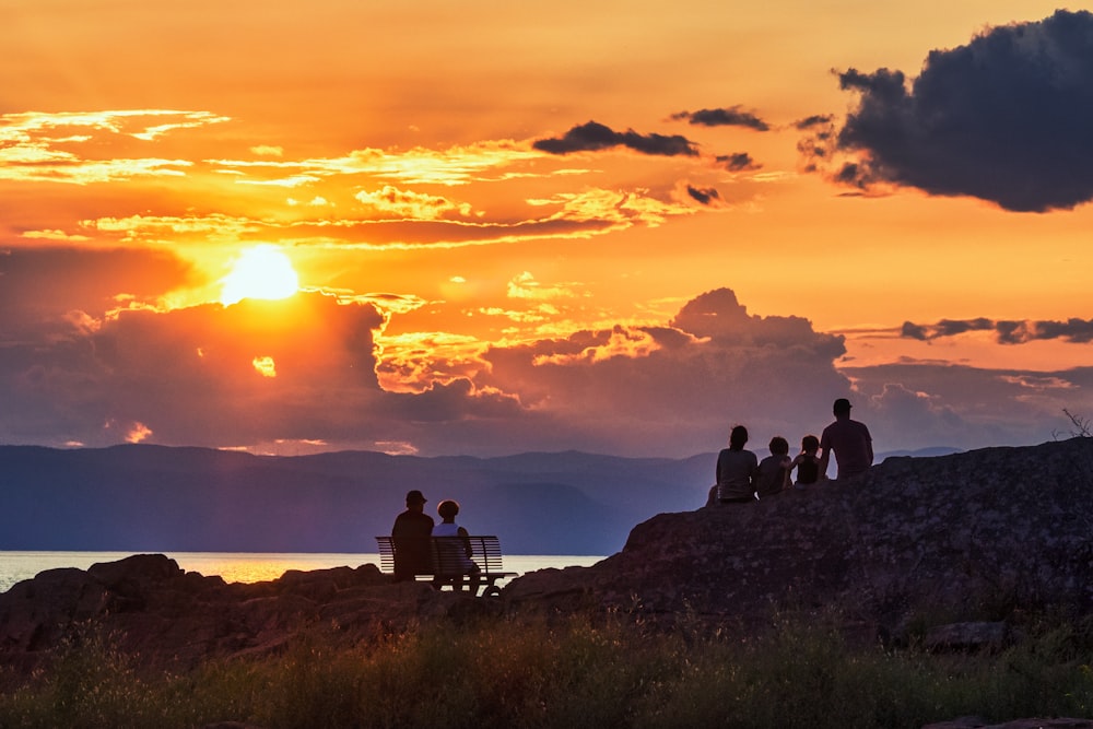 a group of people sitting on top of a rock