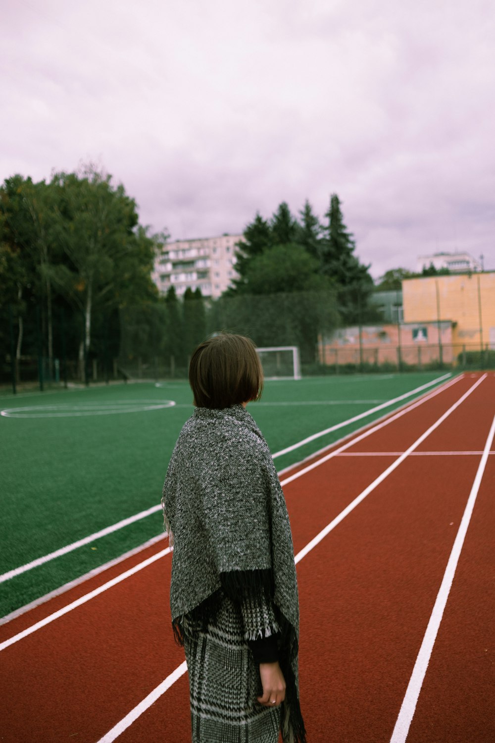 a woman standing on a track holding a purse