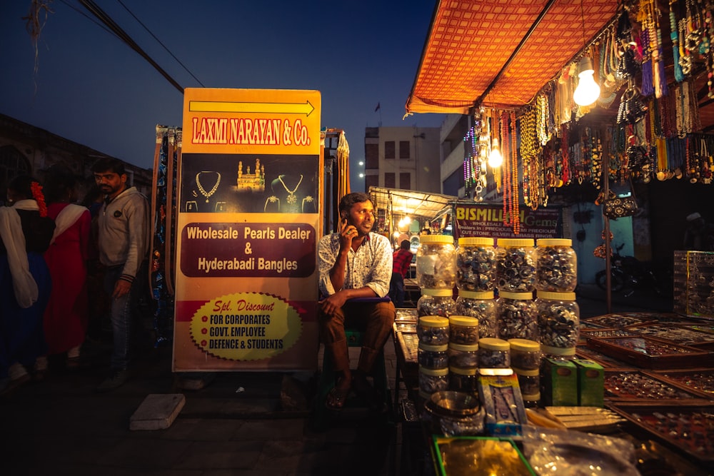 a man sitting in front of a food truck