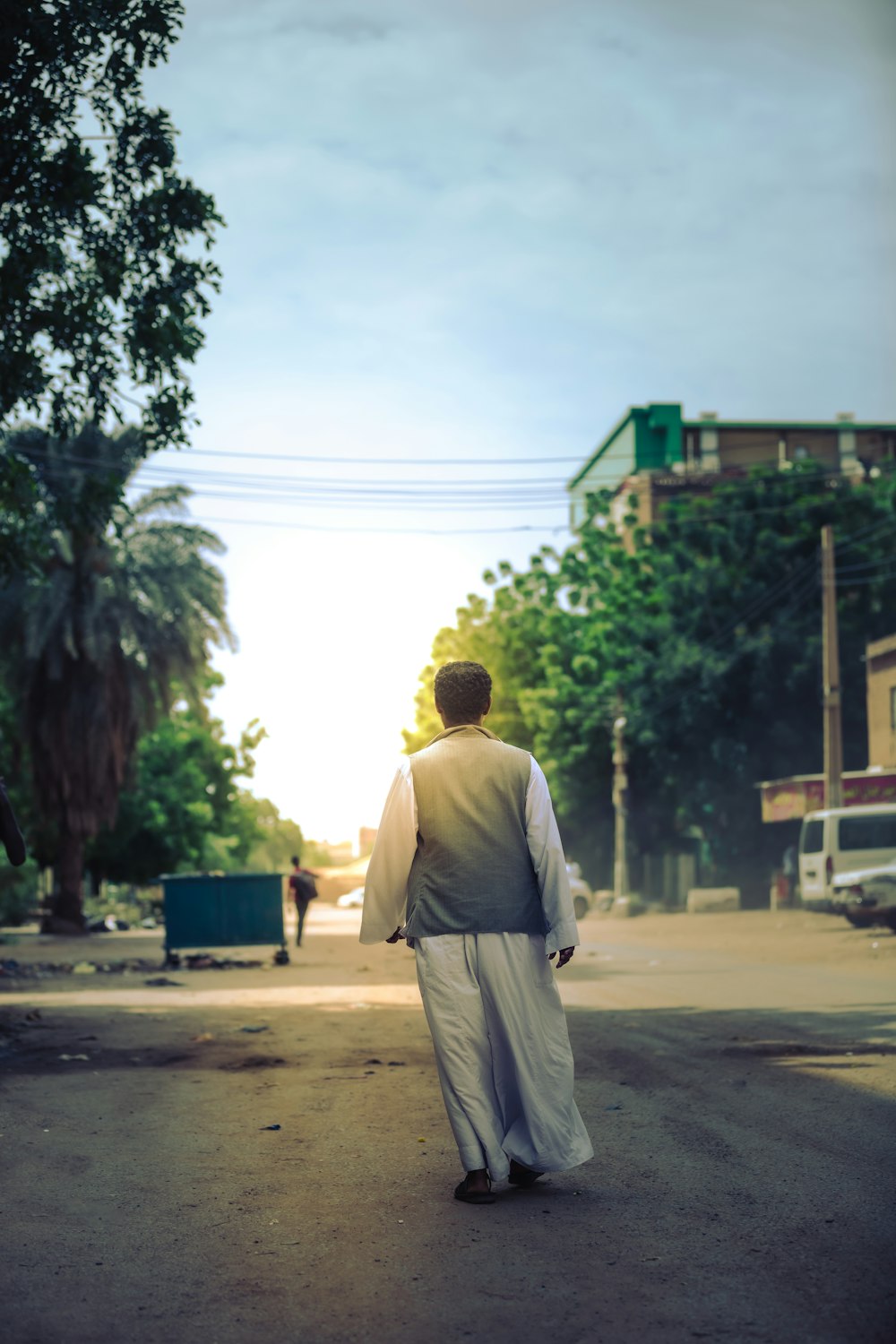 a man is walking down the street in the middle of the day