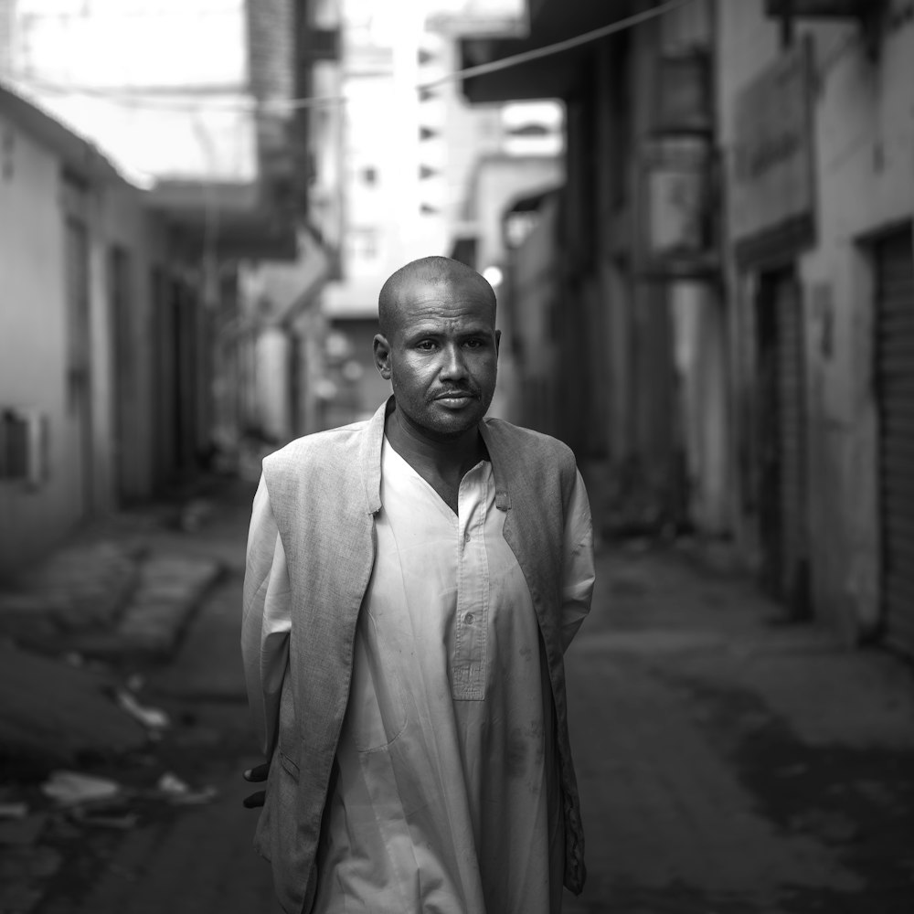 a man standing in a narrow alley way