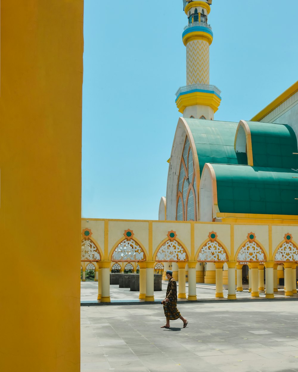 a person walking in front of a yellow and white building