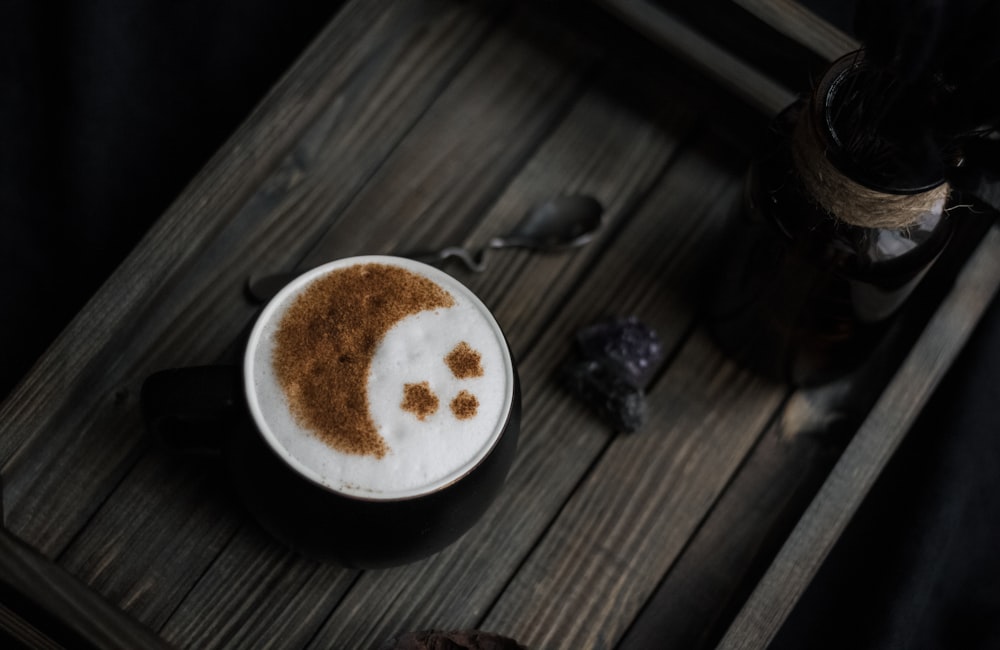 un capuchino con una cara sonriente dibujada en él