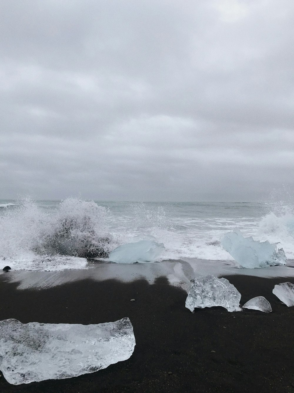 a black sand beach covered in lots of ice