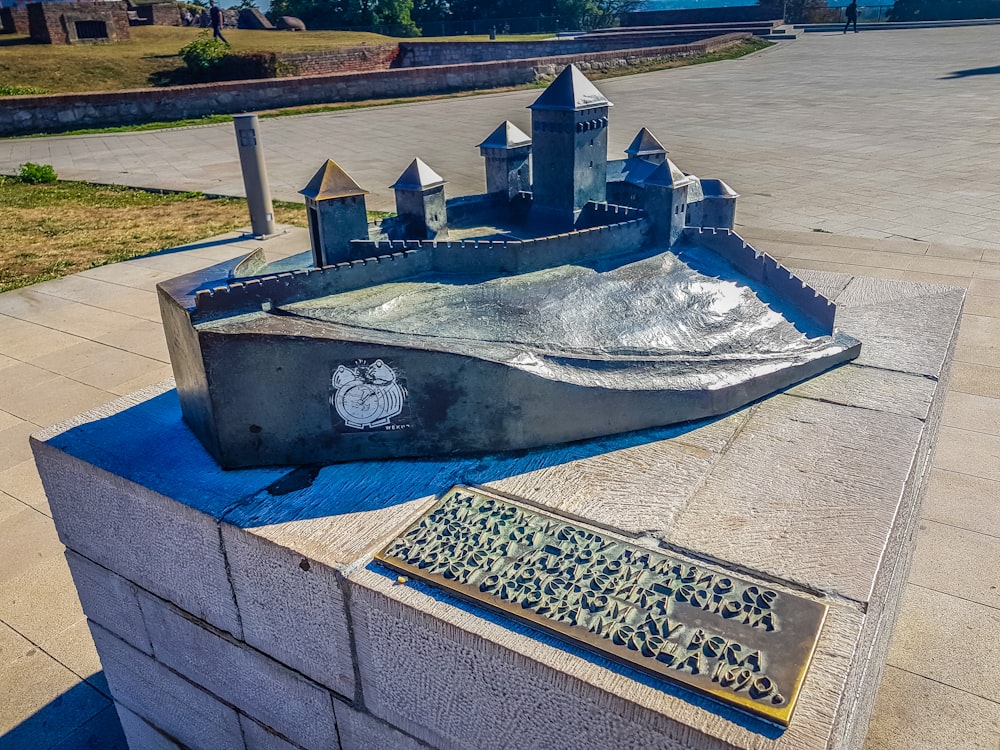 una statua di un castello con una piscina al centro di esso