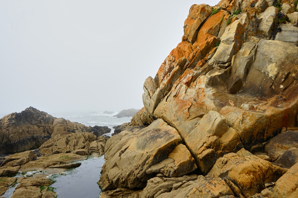 a rocky shore with a body of water