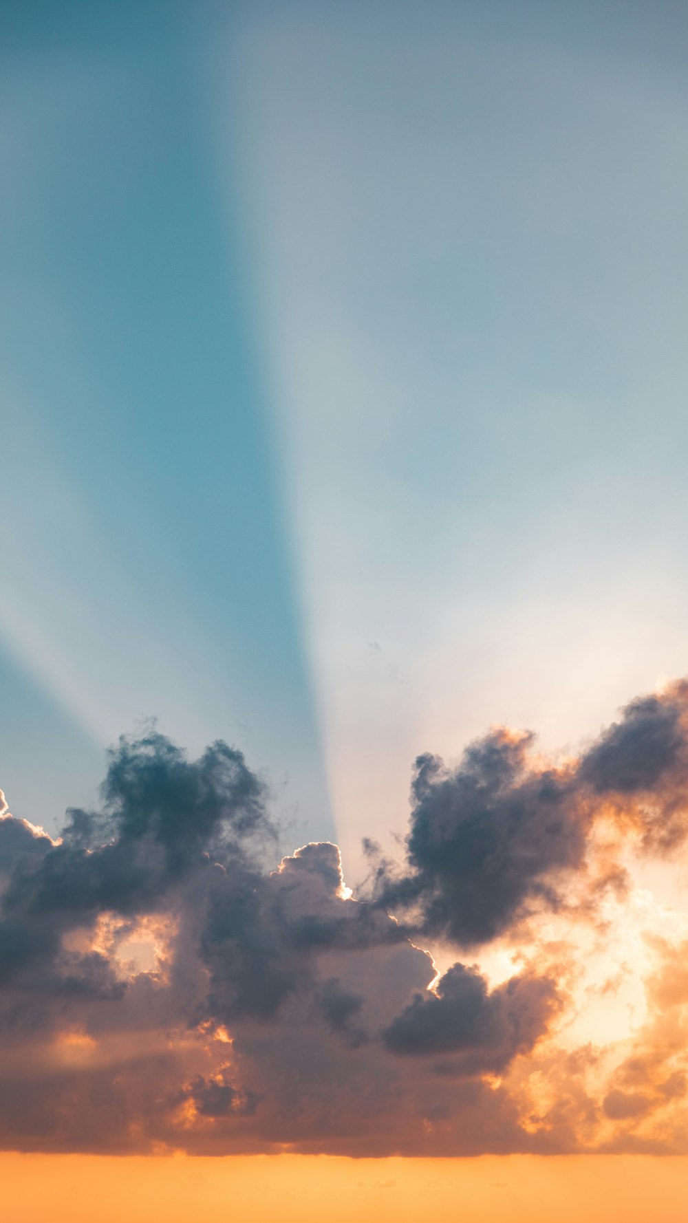 a plane flying in the sky with the sun shining through the clouds