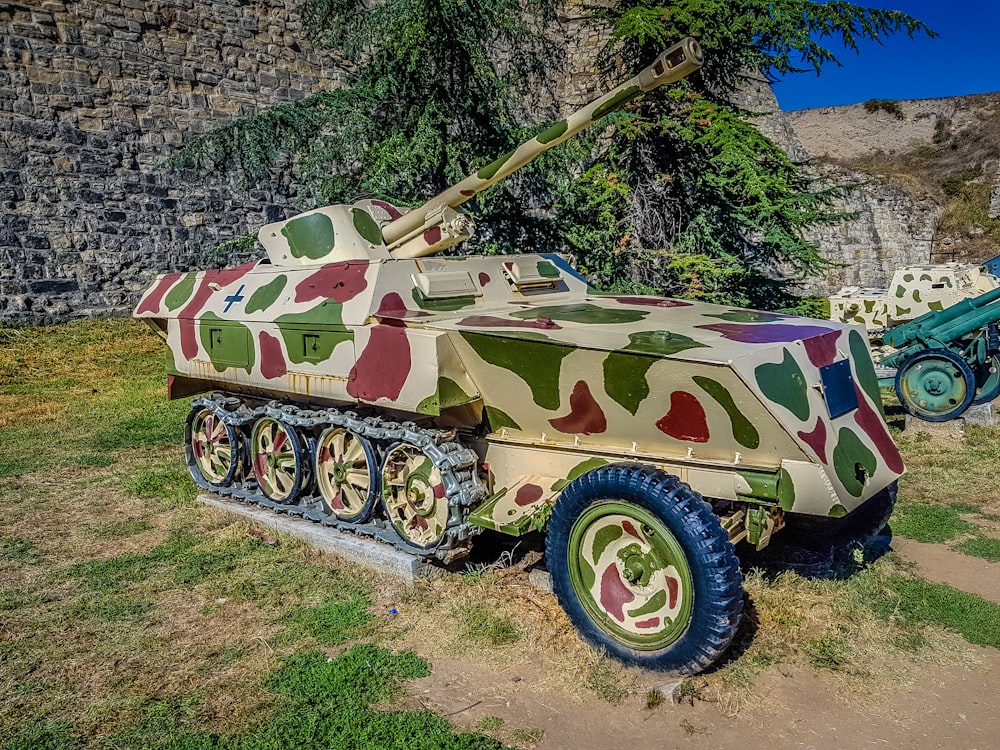 um veículo militar camuflado está estacionado em um campo