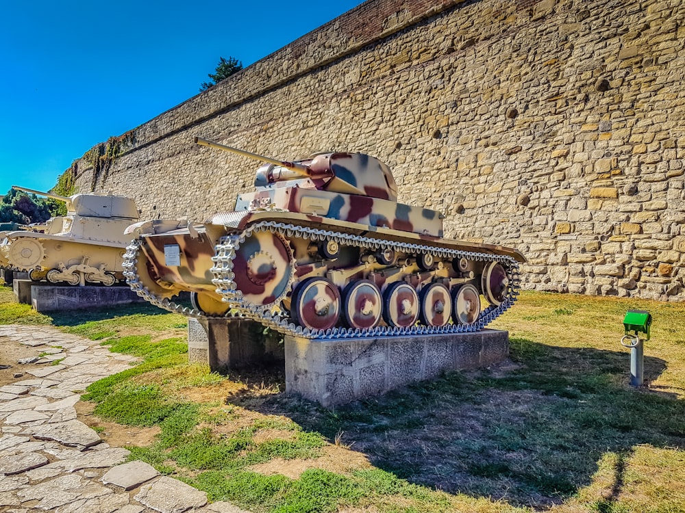 un grande carro armato seduto in cima a un campo coperto di erba