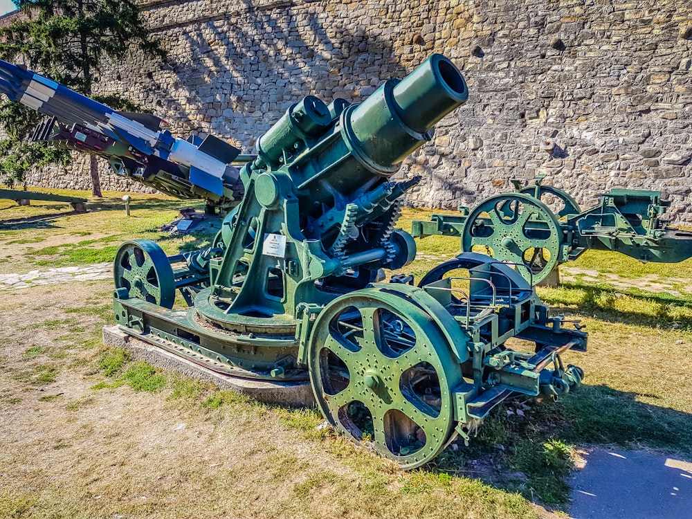 un grande cannone verde seduto in cima a un campo coperto di erba