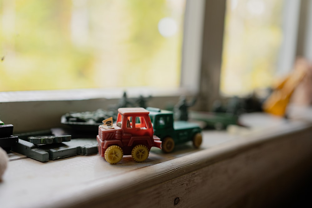 a toy tractor is sitting on a window sill