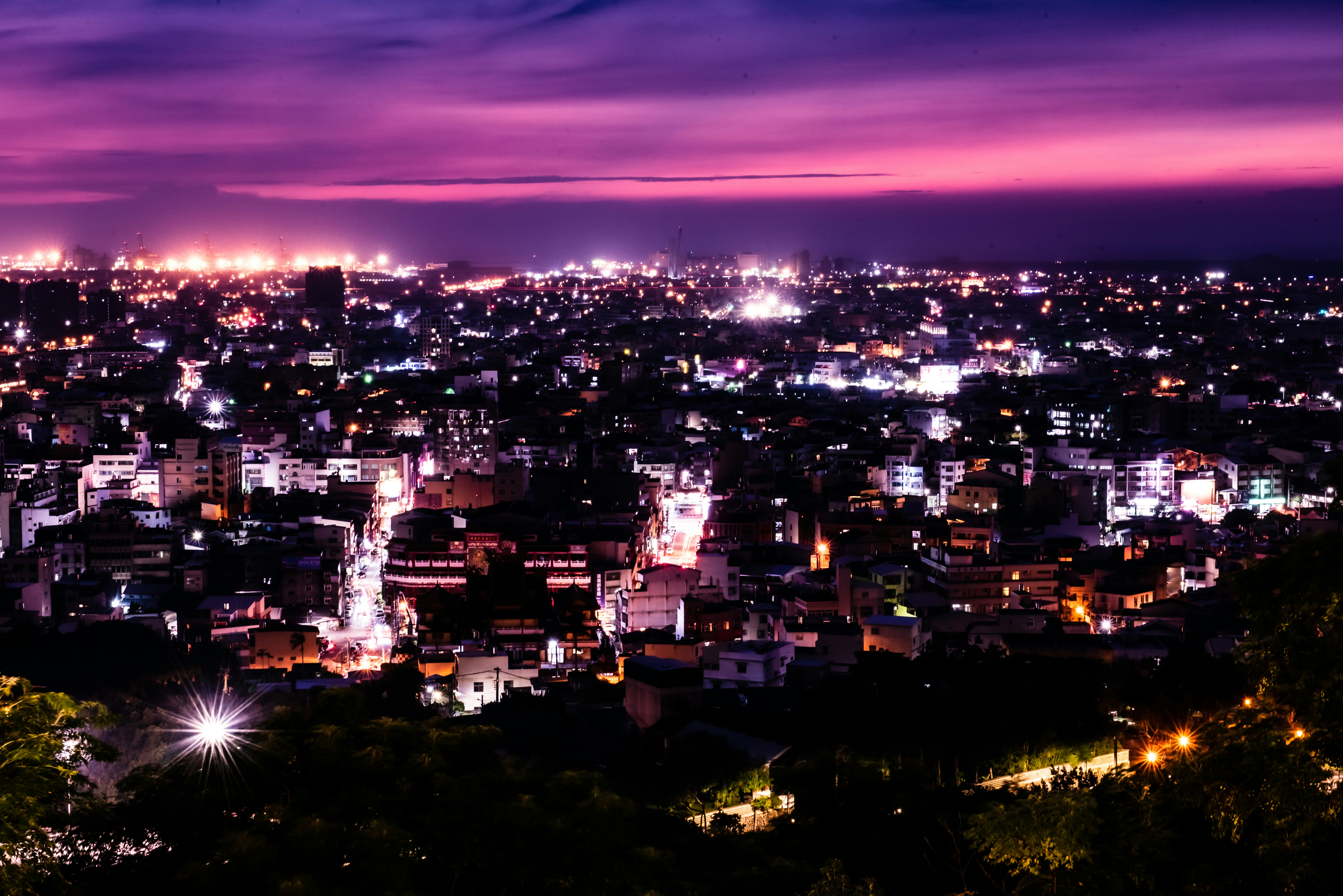 a view of a city at night from the top of a hill