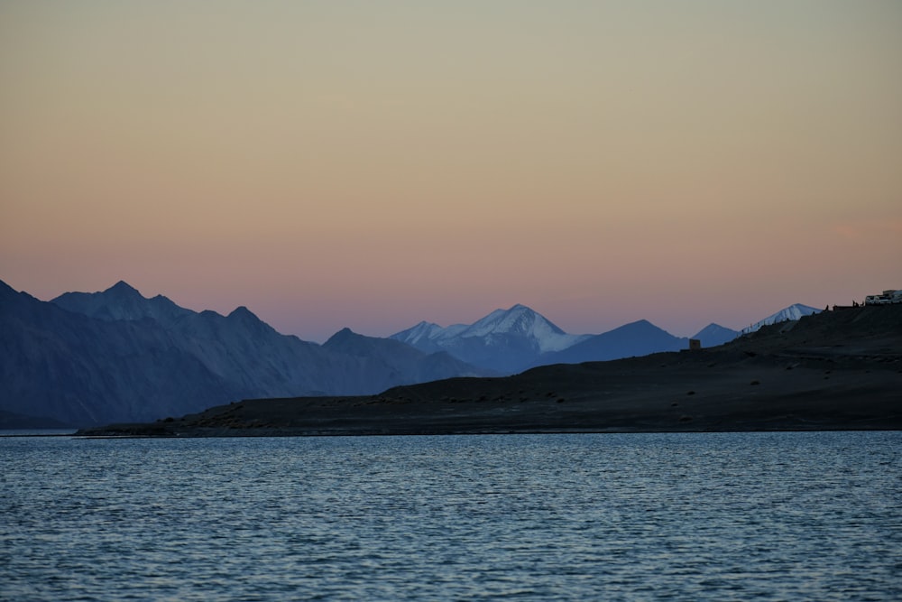 a large body of water with mountains in the background