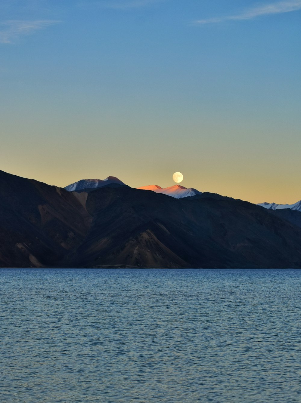 a large body of water with mountains in the background