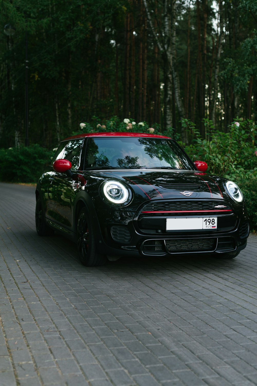 a small black car parked on a brick road