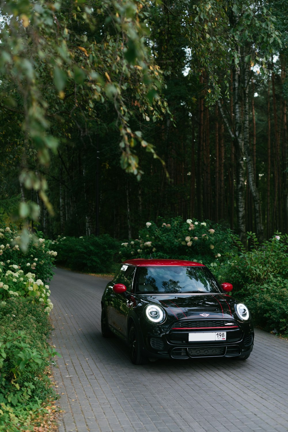 a small black car driving down a road