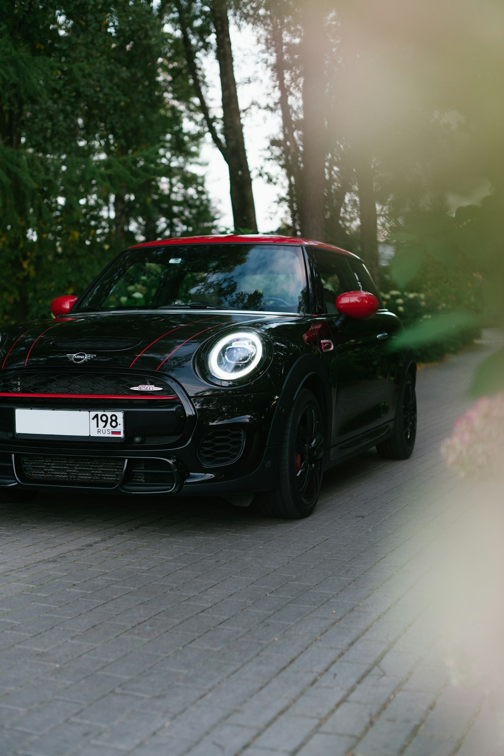 a black and red sports car driving down a street