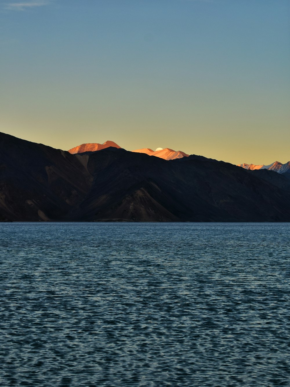 a large body of water with mountains in the background