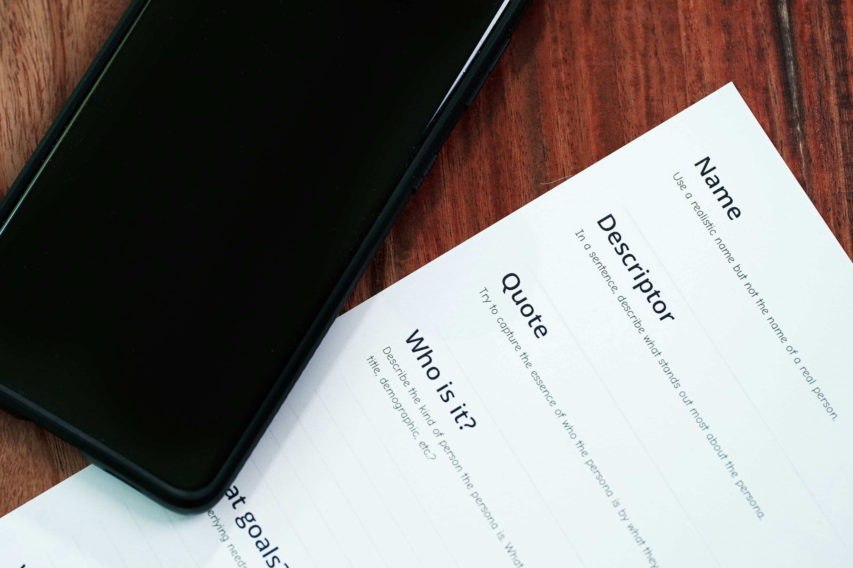 Smartphone beside contract document on wooden desk