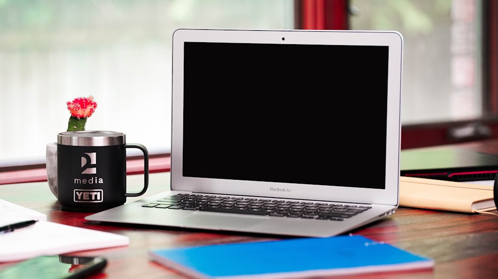 a laptop computer sitting on top of a wooden desk