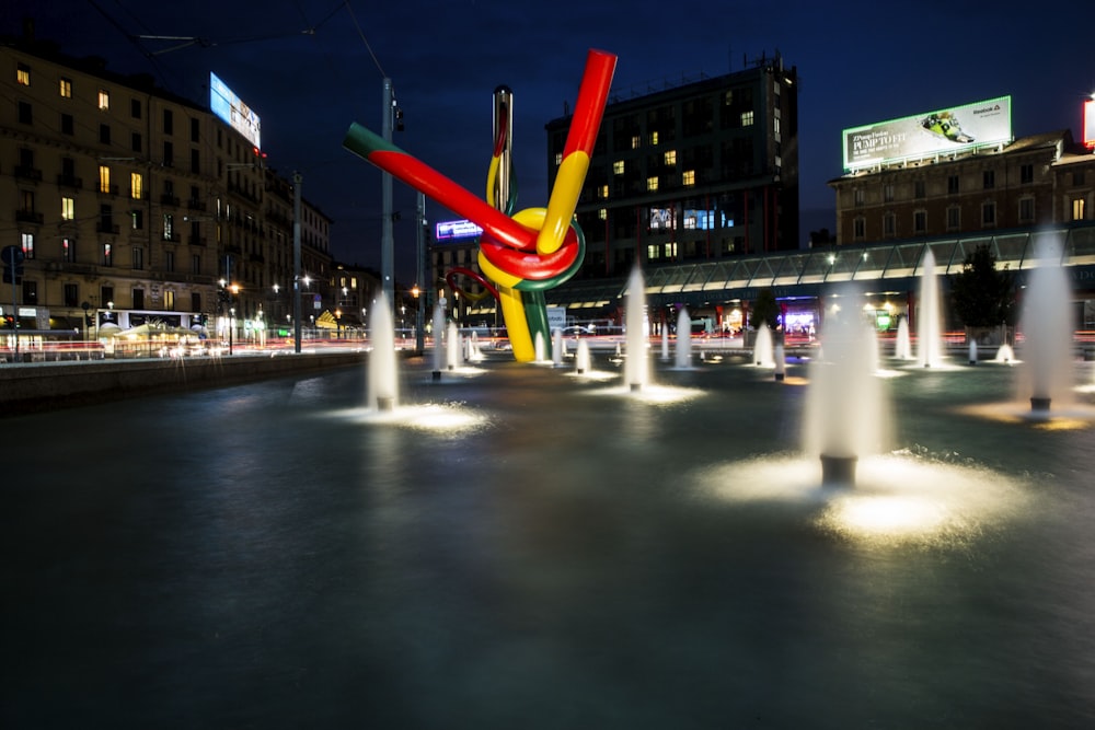 a colorful sculpture is in the middle of a fountain