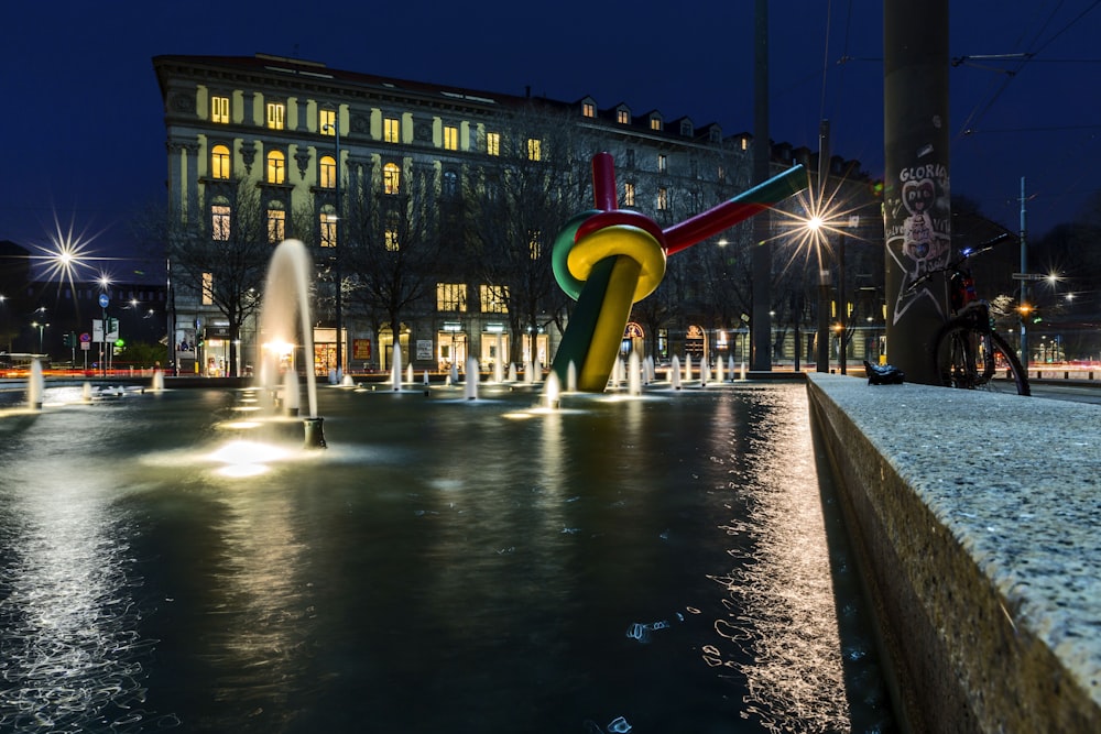 a fountain in a city square with a building in the background