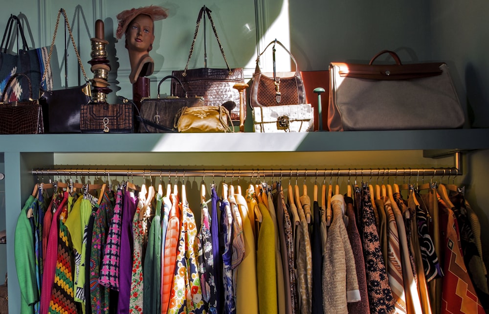 a shelf with a bunch of clothes and handbags on it