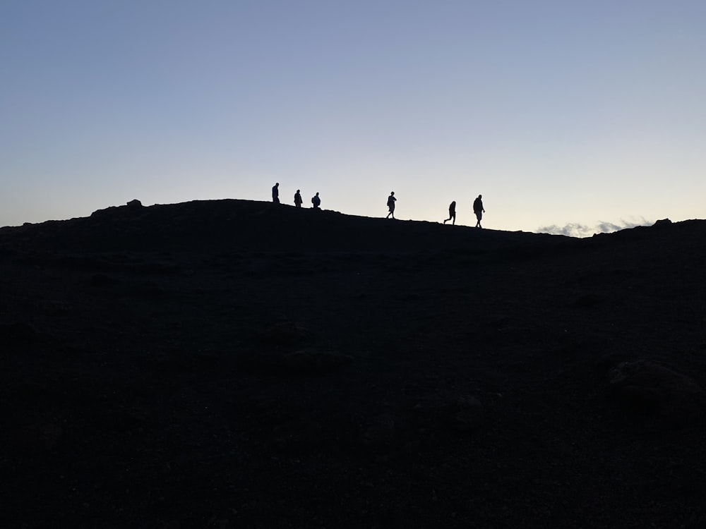 a group of people standing on top of a hill