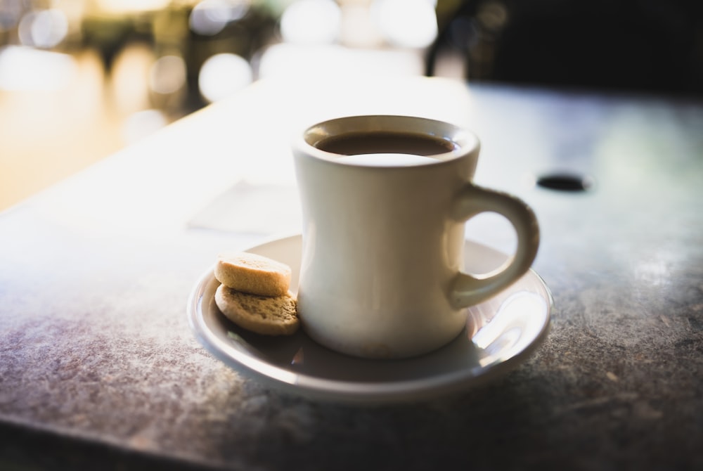 a cup of coffee and a biscuit on a table