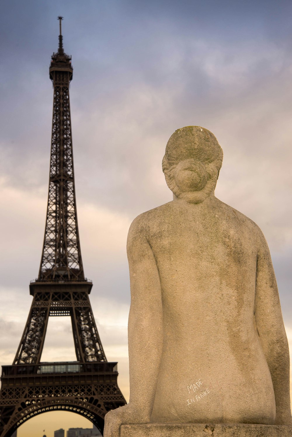 a statue of a man in front of the eiffel tower