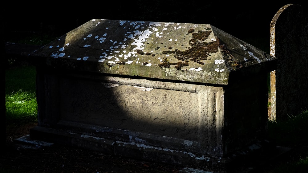 an old grave with moss growing on it