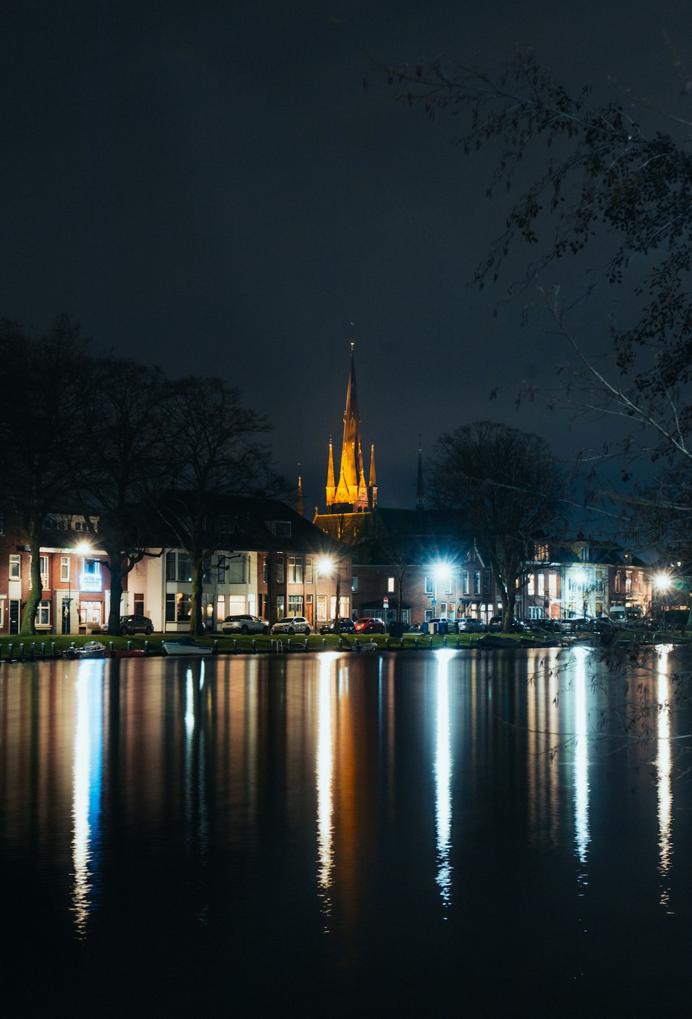 a night view of a lake with a church in the background