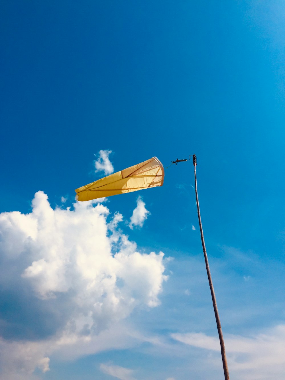 a yellow umbrella sitting on top of a wooden pole