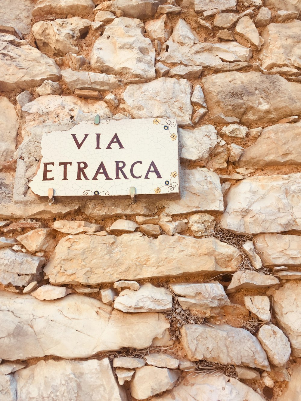 a stone wall with a sign on it