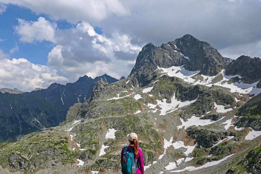 a woman standing on top of a snow covered mountain