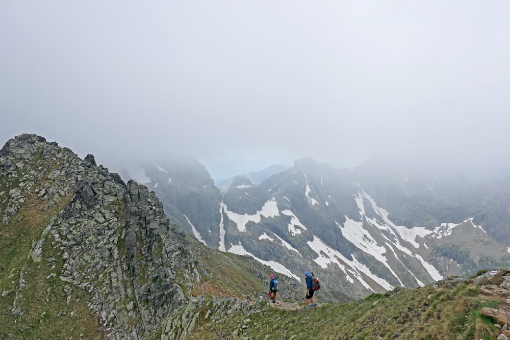 Un couple de personnes debout au sommet d’une montagne