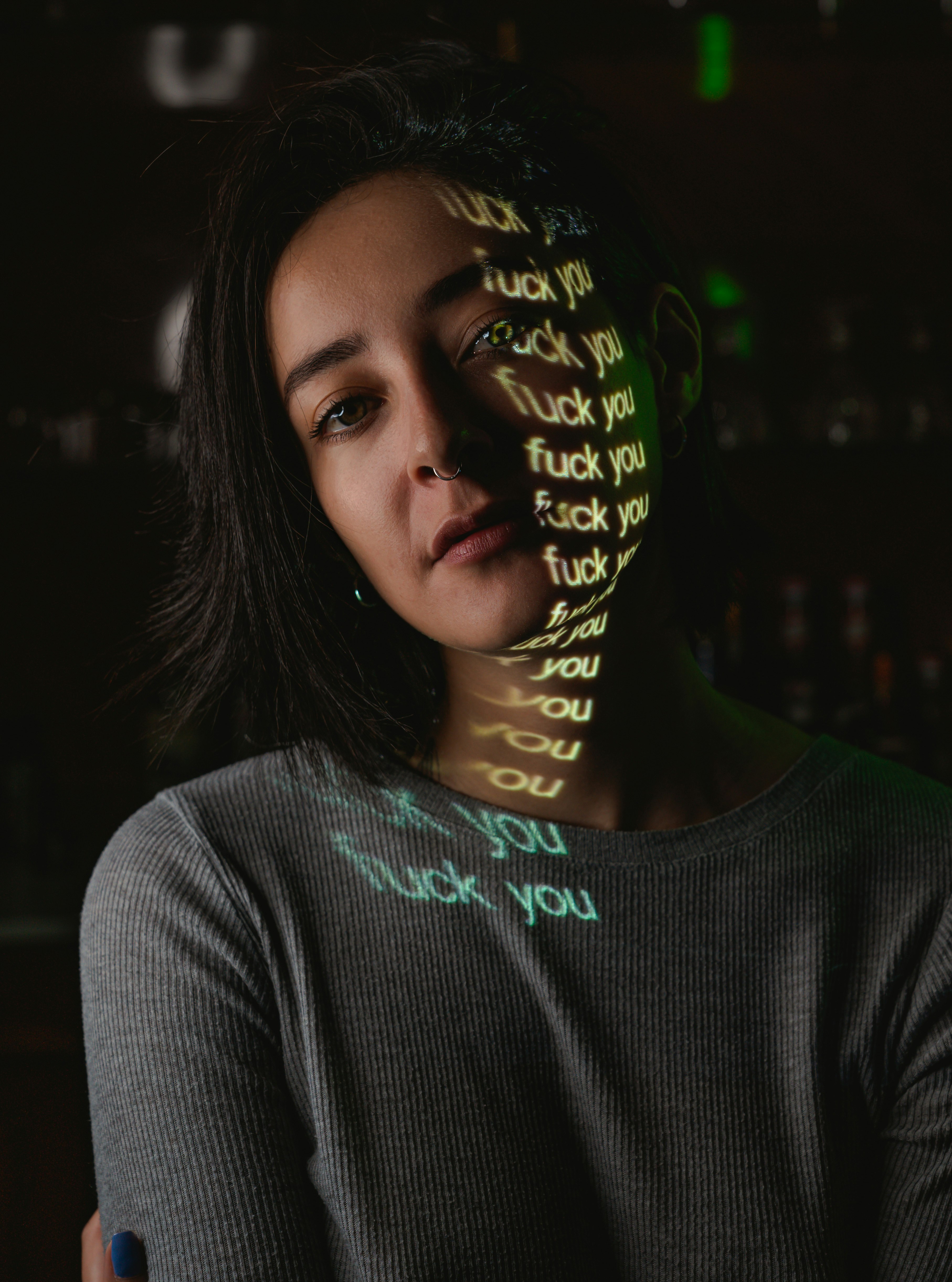 girl posing for portrait with projection of letter on her face