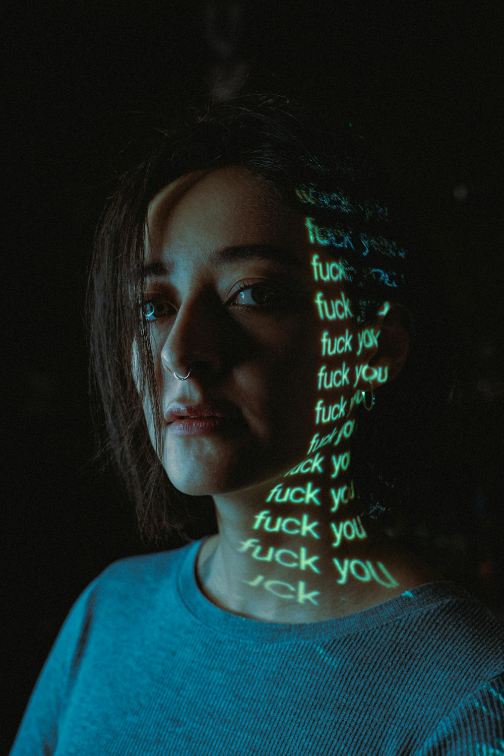 Una donna con il volto coperto di scritte al neon