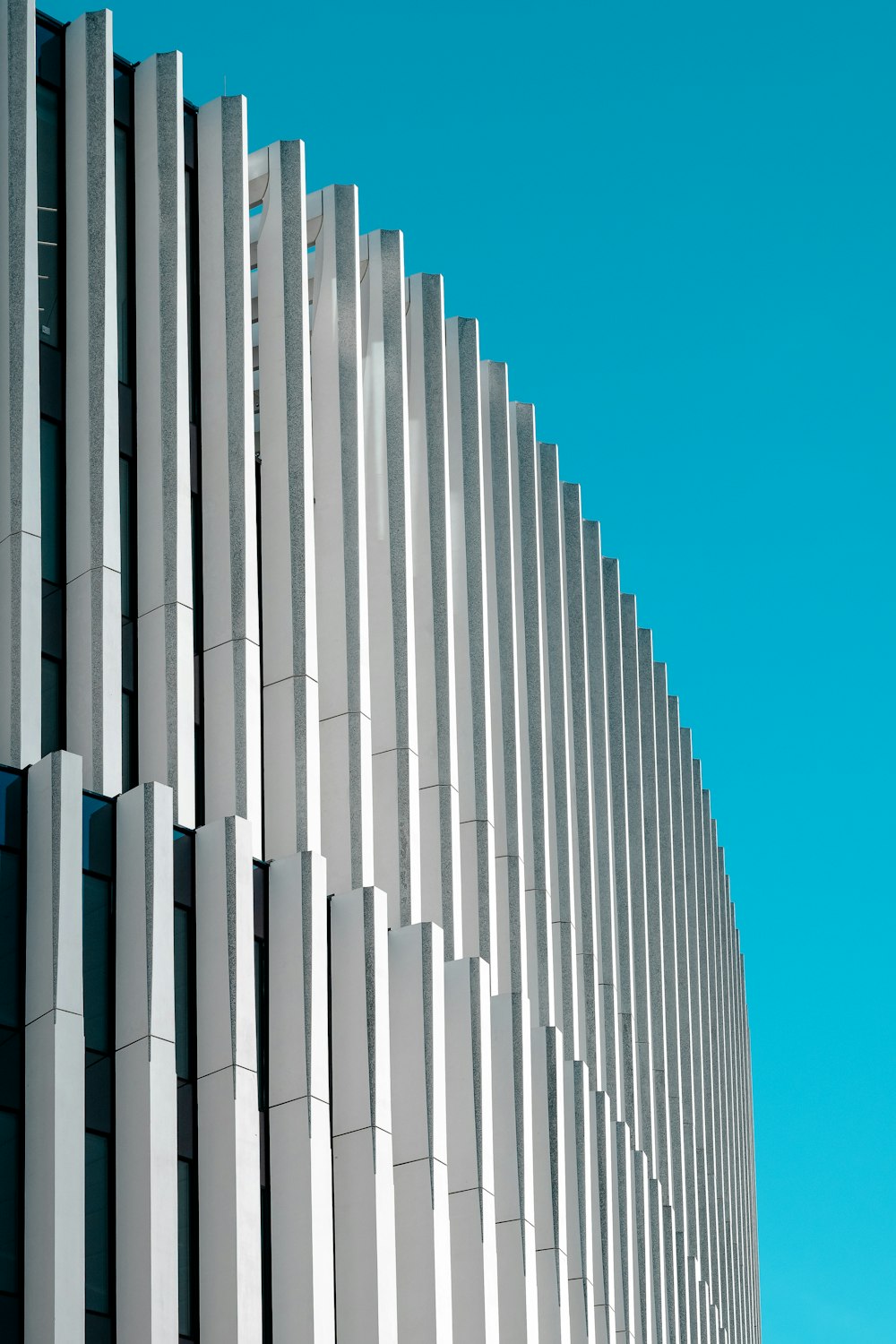 a tall white building with a blue sky in the background