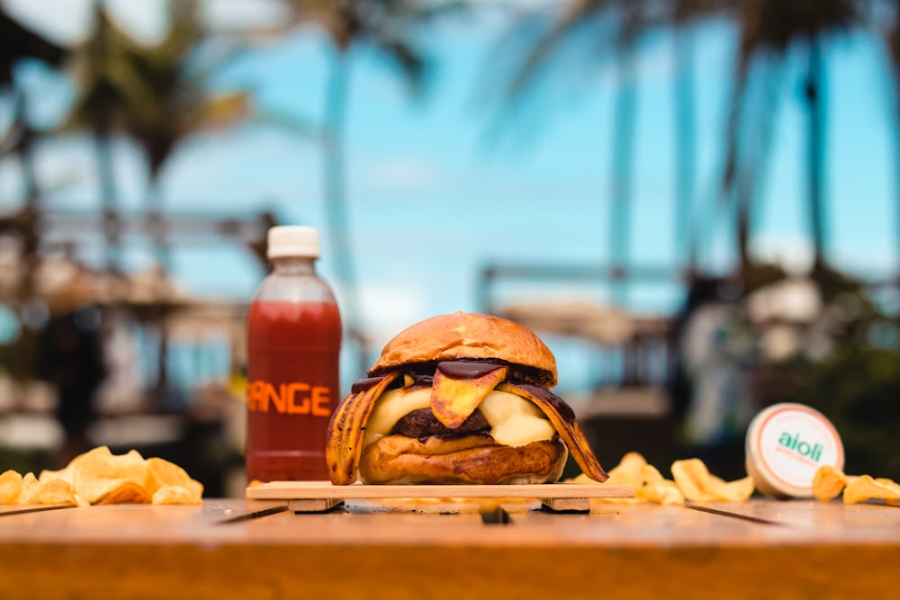 a burger and a bottle of juice on a table