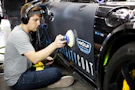 a man is painting a car with a spray gun