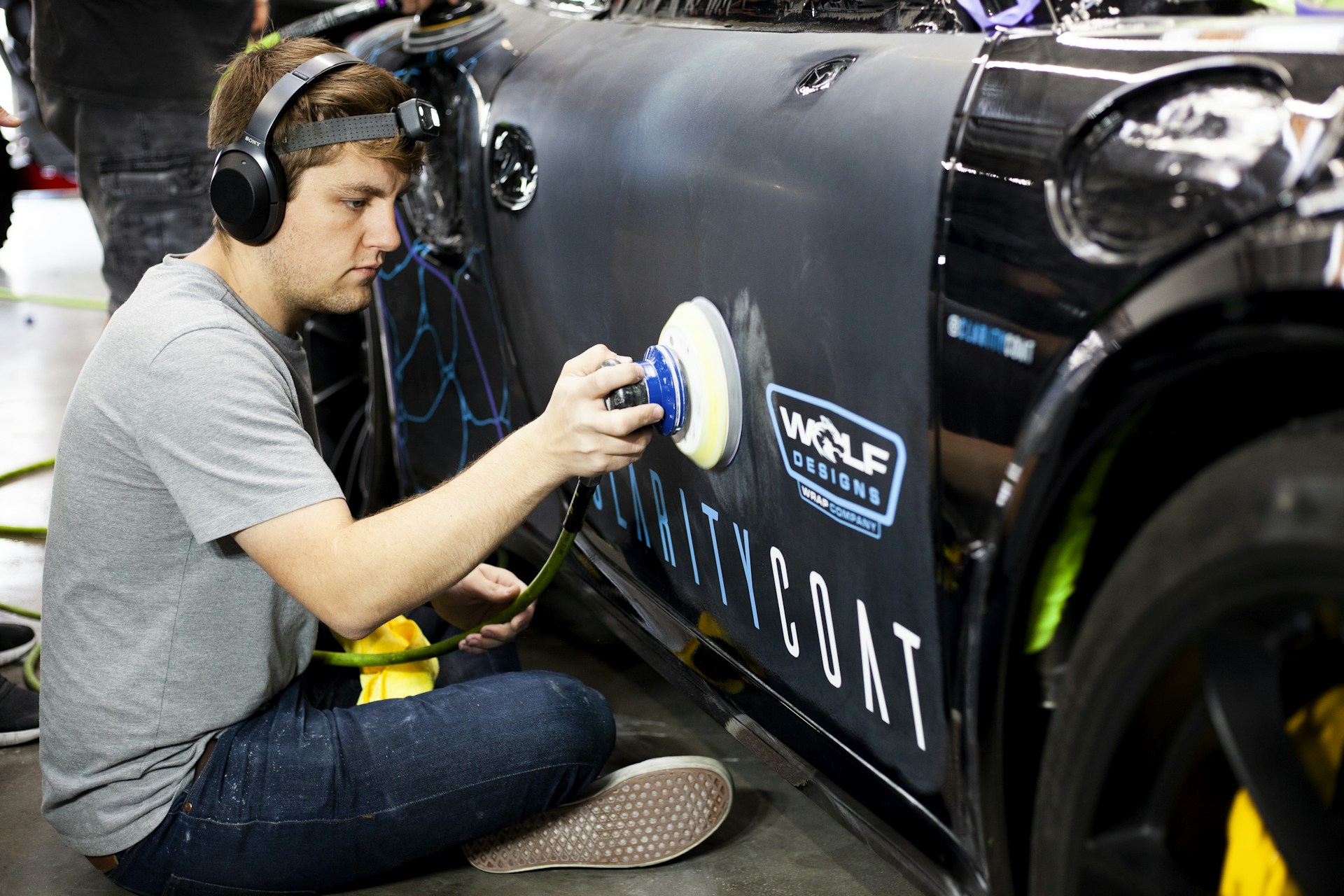 a man is painting a car with a spray gun