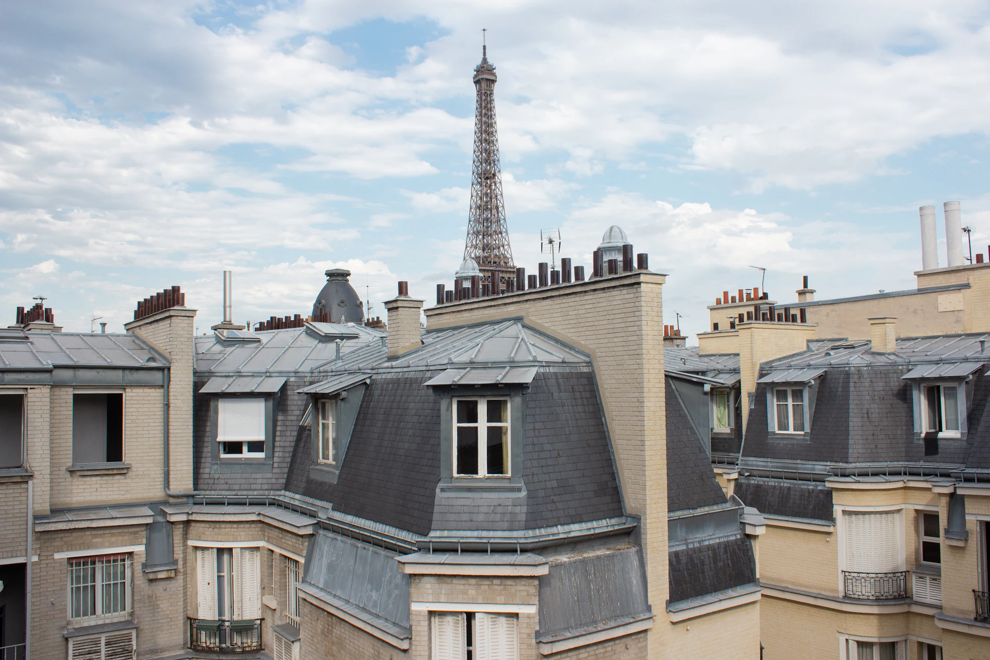 Toits en zinc d'immeubles parisiens, la tour Eiffel au loin