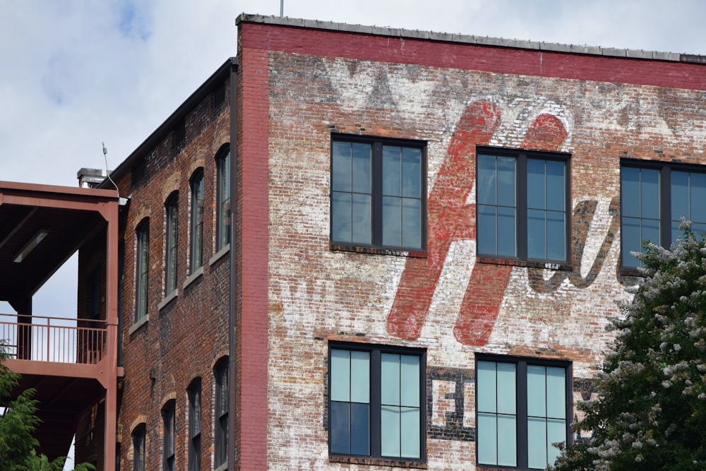 an old brick building with windows and a sign painted on it