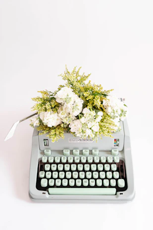 A vintage typewriter with a fresh poem typed on crisp white paper, surrounded by scattered petals.